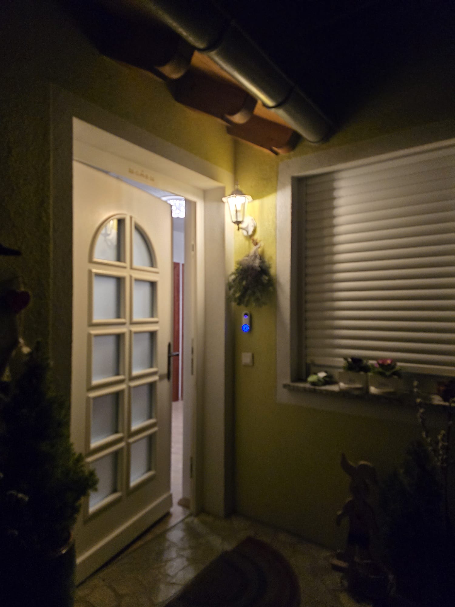 Beleuchteter Hauseingang mit offener Tuer und smarter Aussenbeleuchtung